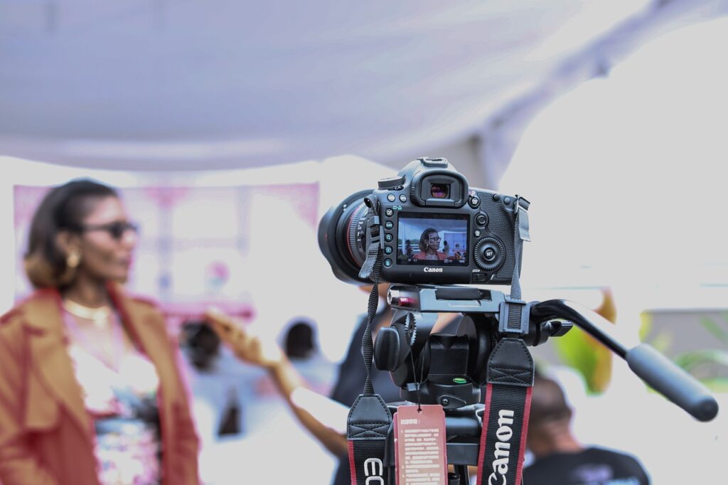 Camera in focus pointing towards woman being interviewed out of focus